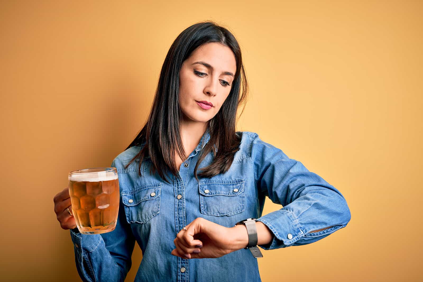 woman drinking and looking at watch to calculate how long after drinking can you drive in Utah