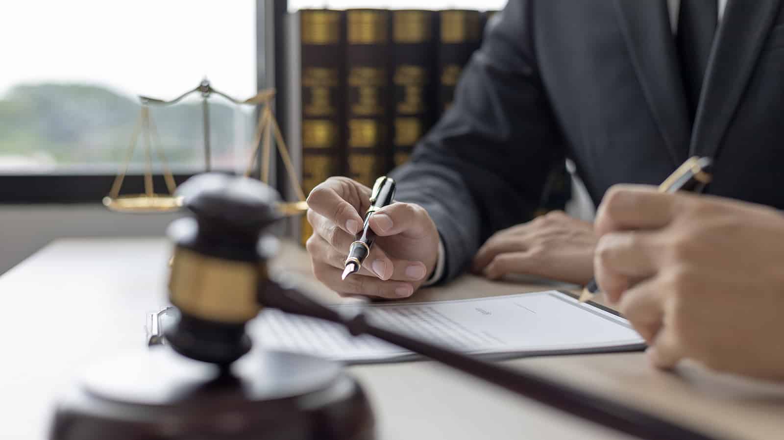 lawyer and client reviewing Utah order to show cause next to justice scale and gavel